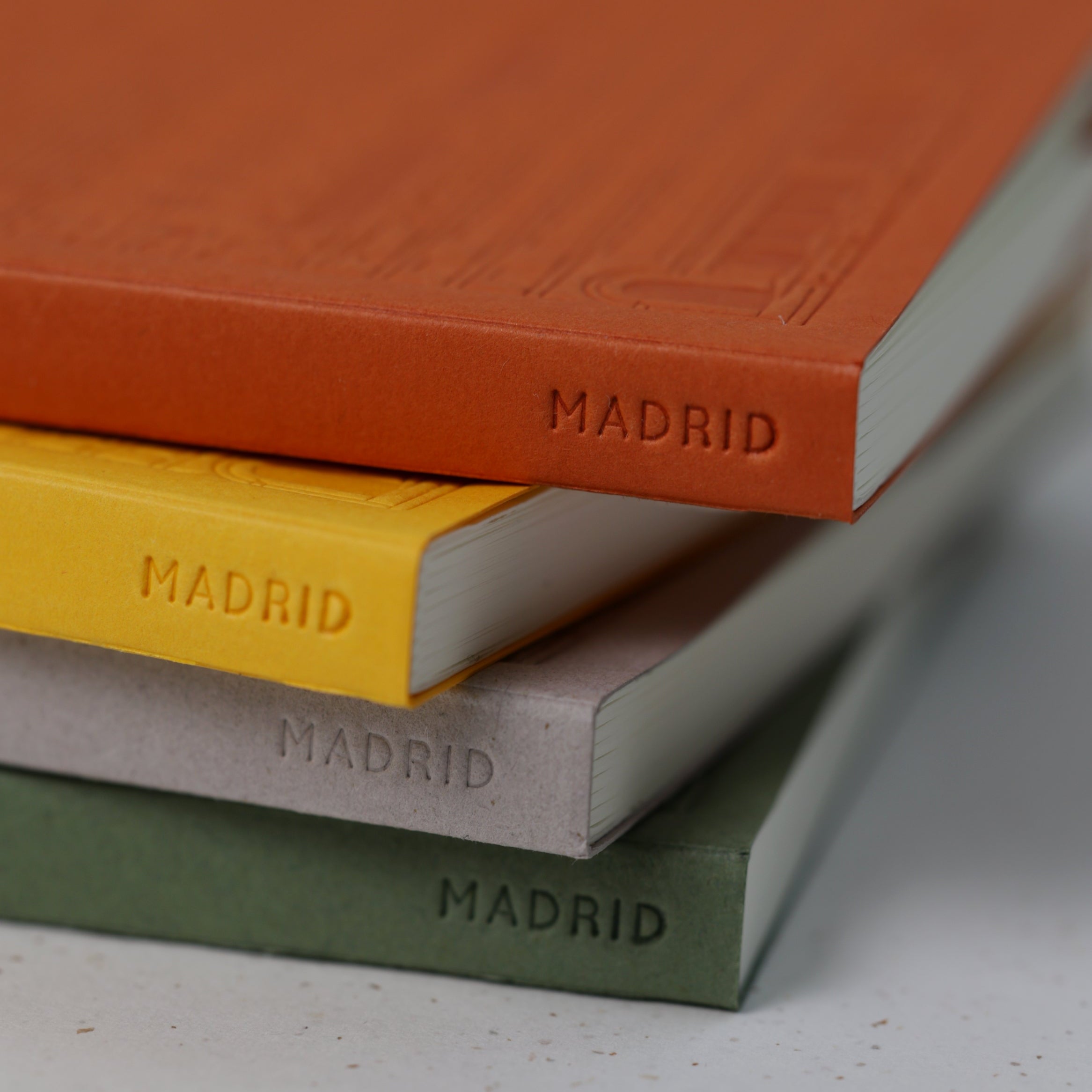 Stack of books with 'Madrid' embossed on their spines, on a light background. Produced by The City Works